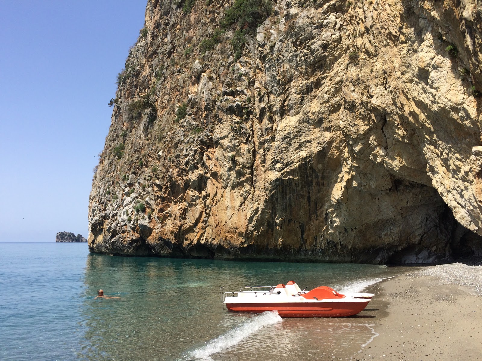 Foto de Cala delle Ossa com areia cinza e seixos superfície
