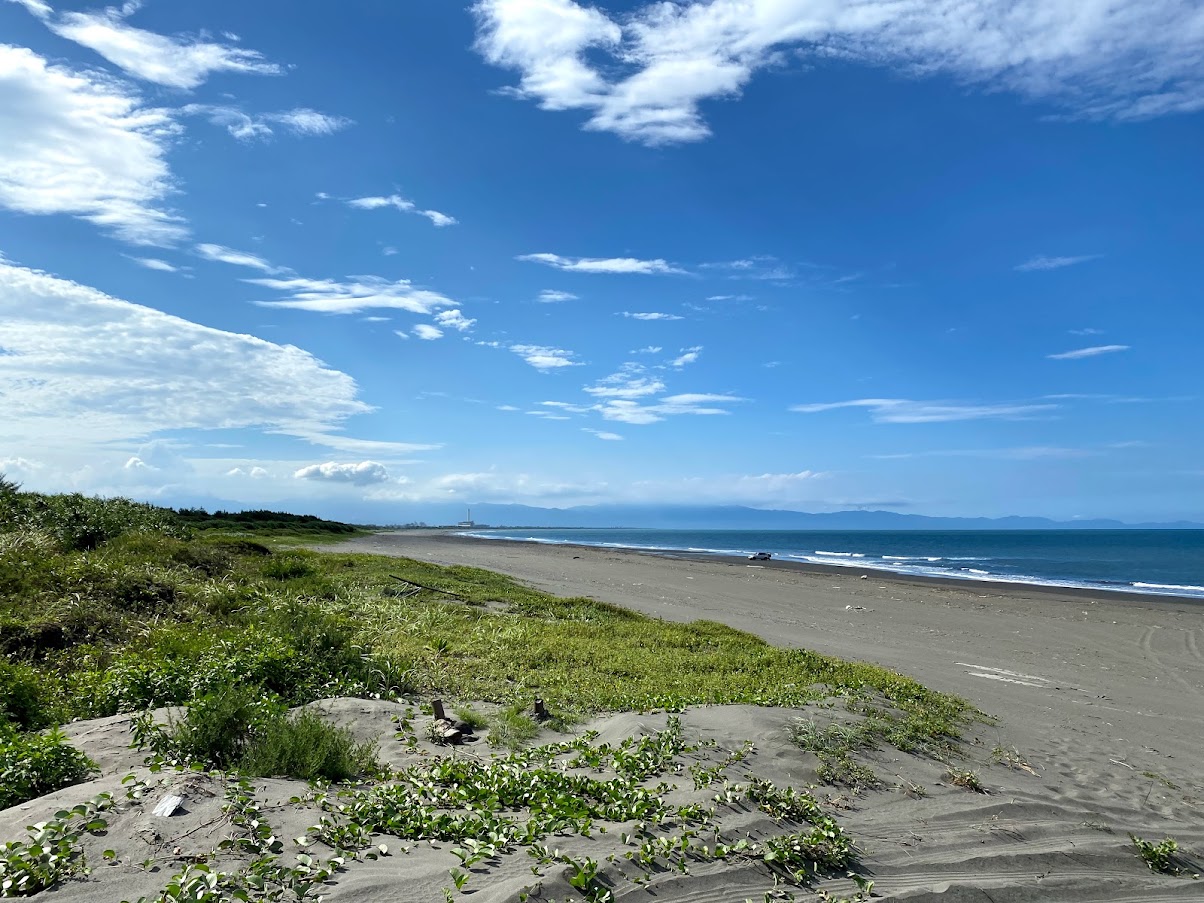 Foto de Wuweigang Beach con arena gris y piedras superficie