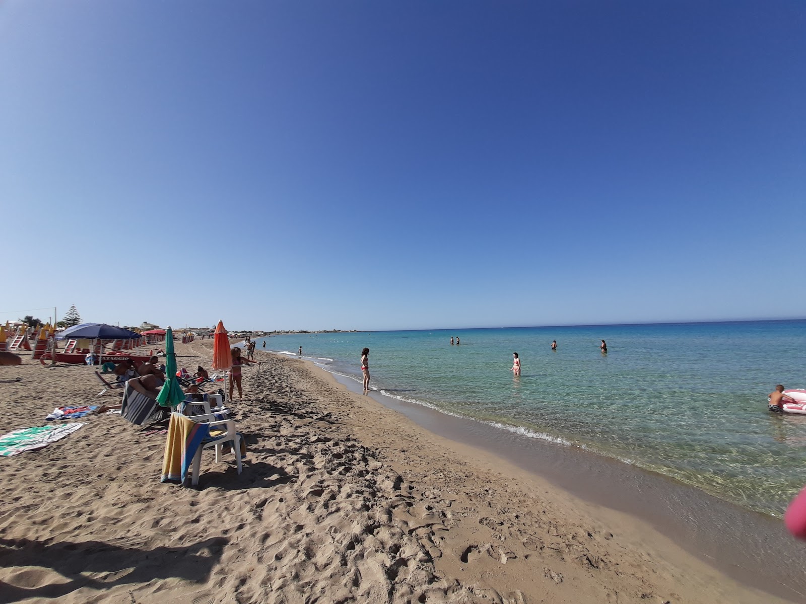 Foto di Spiaggia del Villaggio Greco con una superficie del sabbia beige fine
