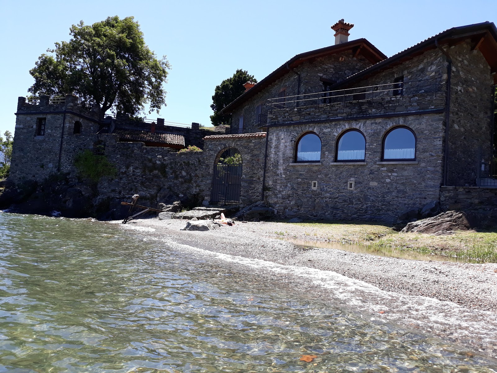 Foto von Spiaggia Santa Maria Rezzonico von Klippen umgeben