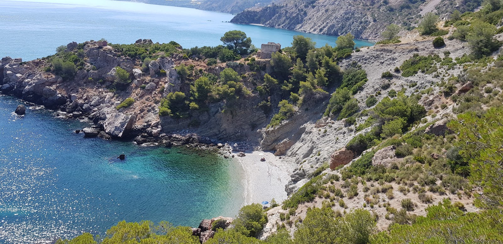 Foto di La Caleta beach con una superficie del ciottolo fine bianco