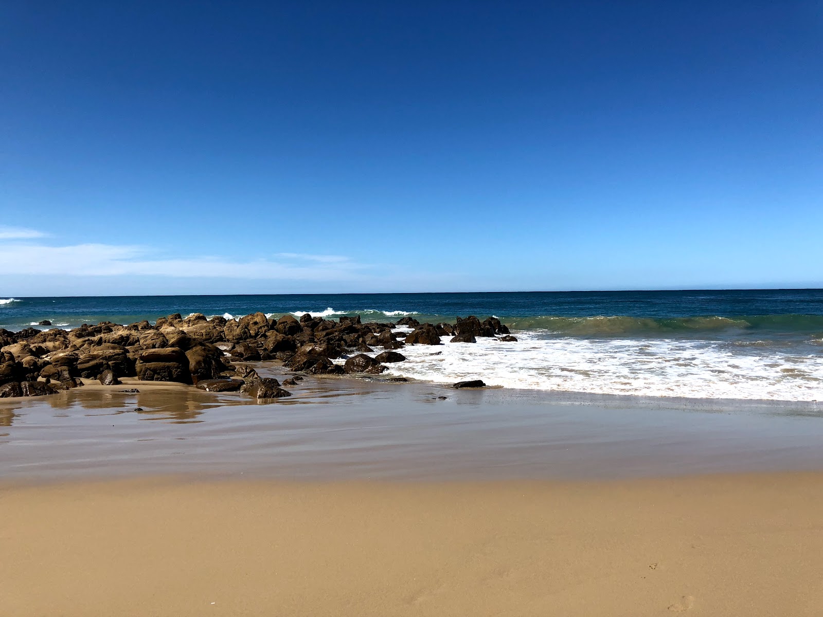 Foto av Cintsa beach med stenar yta