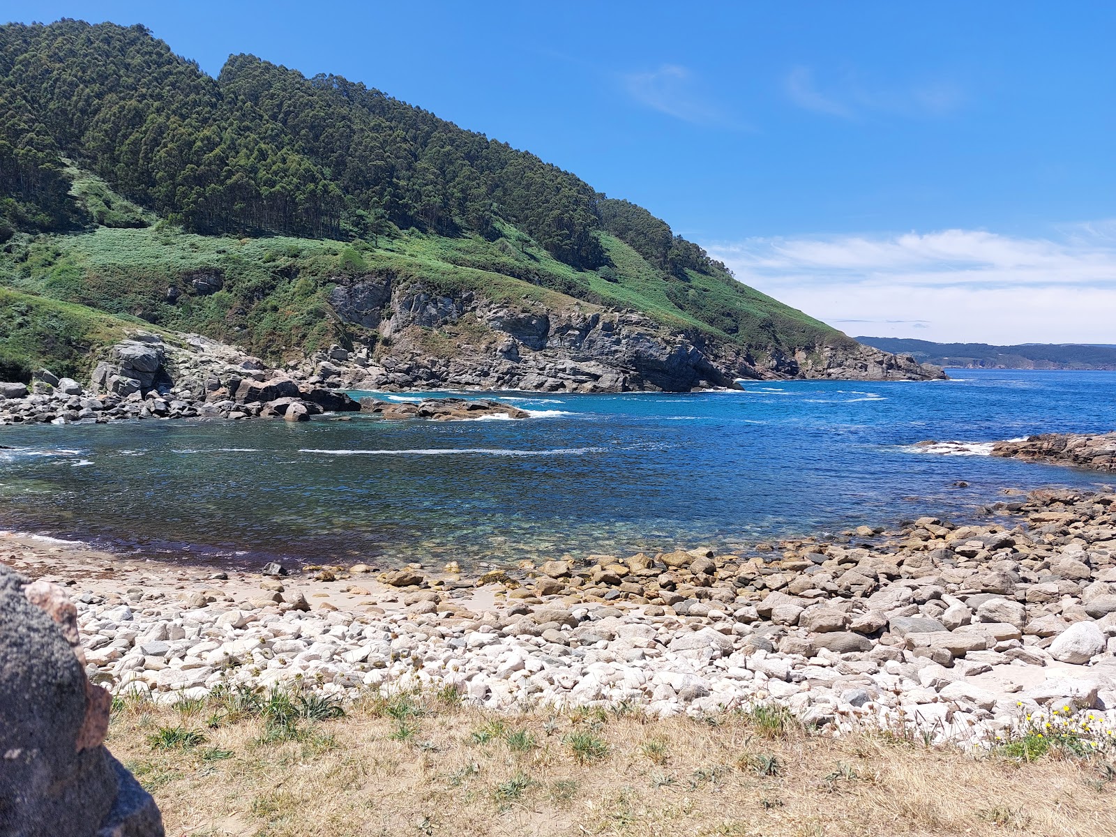 Foto di Praia de Portonovo con una superficie del sabbia beige e rocce