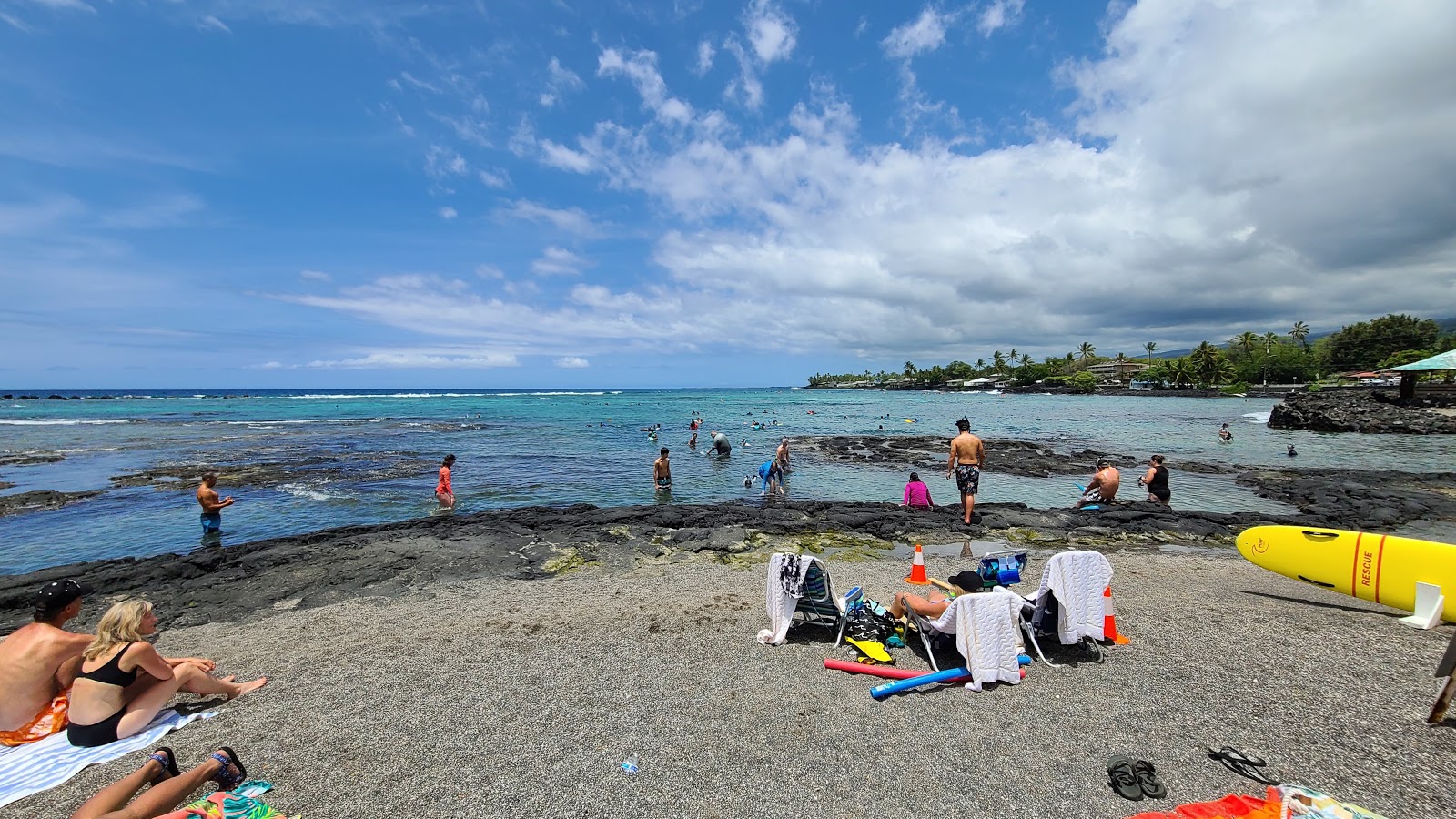 Foto di Kahalu'u Beach con una superficie del sabbia grigia e rocce