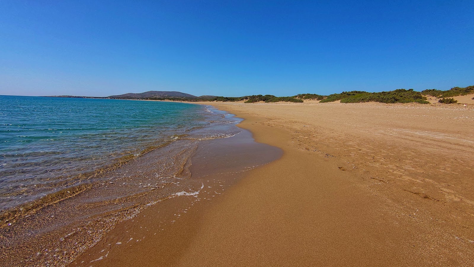 Foto de Agios Georgios Beach com areia marrom superfície