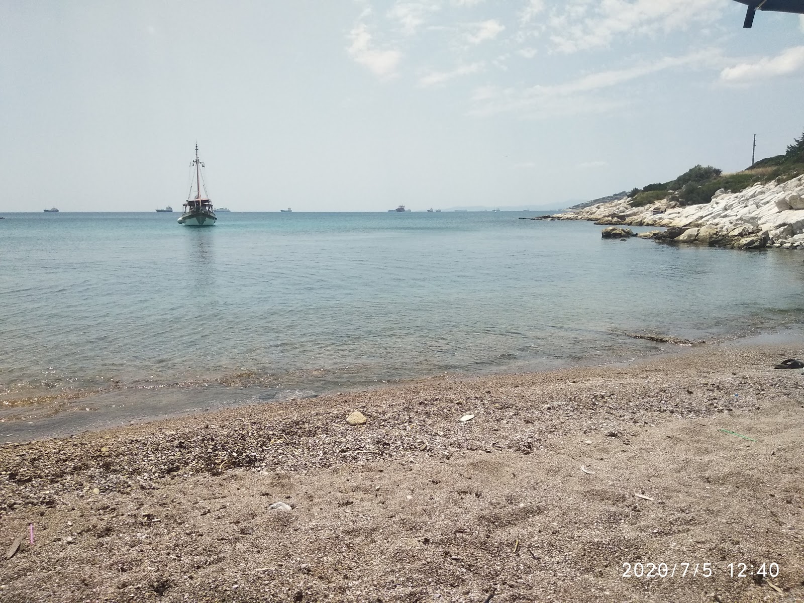 Foto av Paralia Kynosouras med musta hiekka ja kivi yta