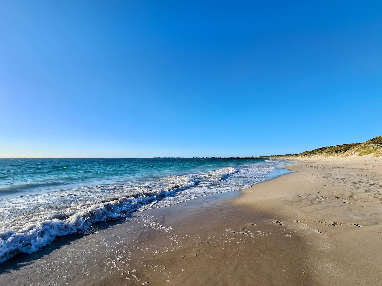 Valokuva Port Kennedy Nudist Beachista. pinnalla kirkas hiekka:n kanssa