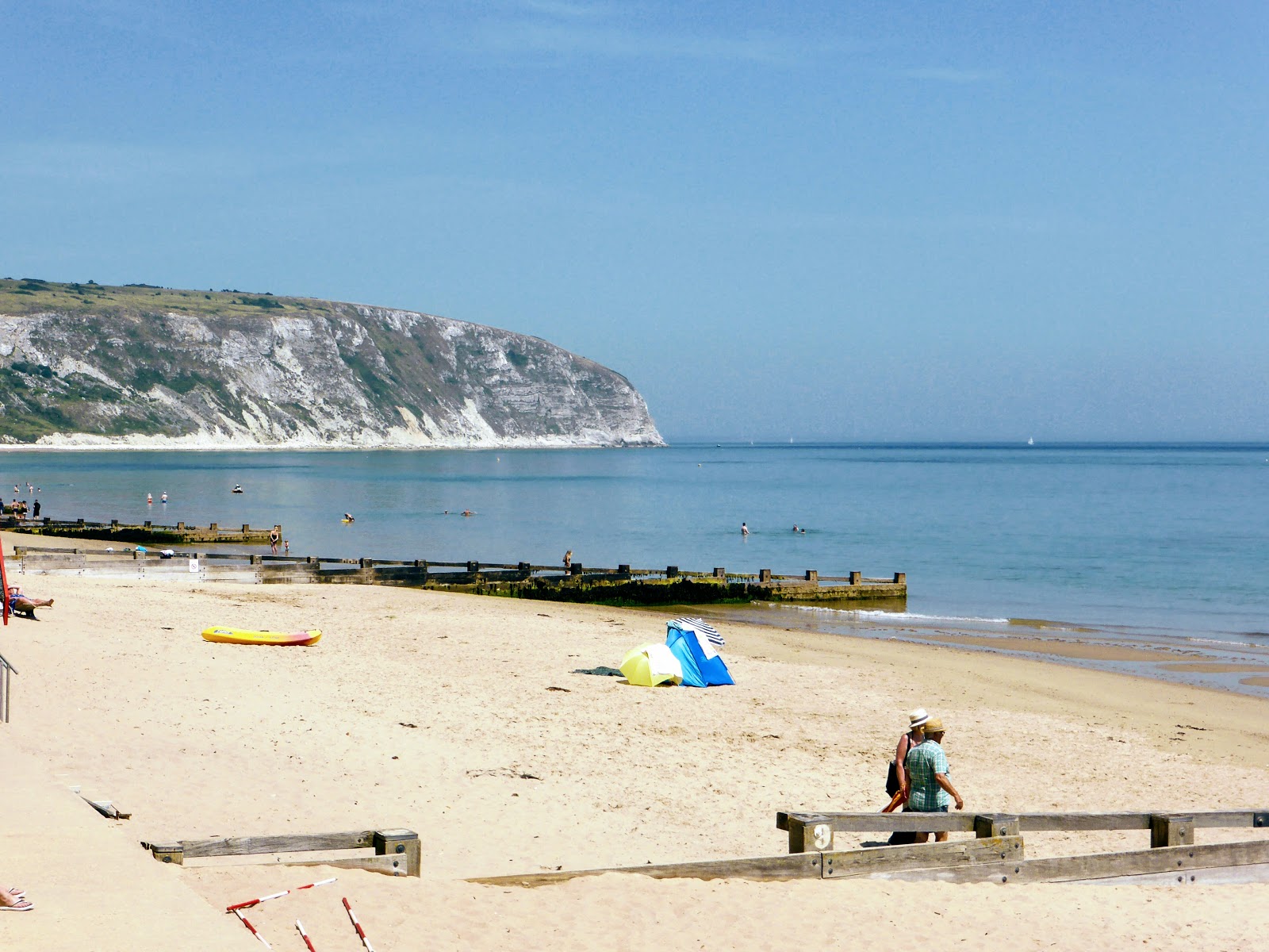 Fotografie cu Golful Swanage cu o suprafață de nisip beige fin