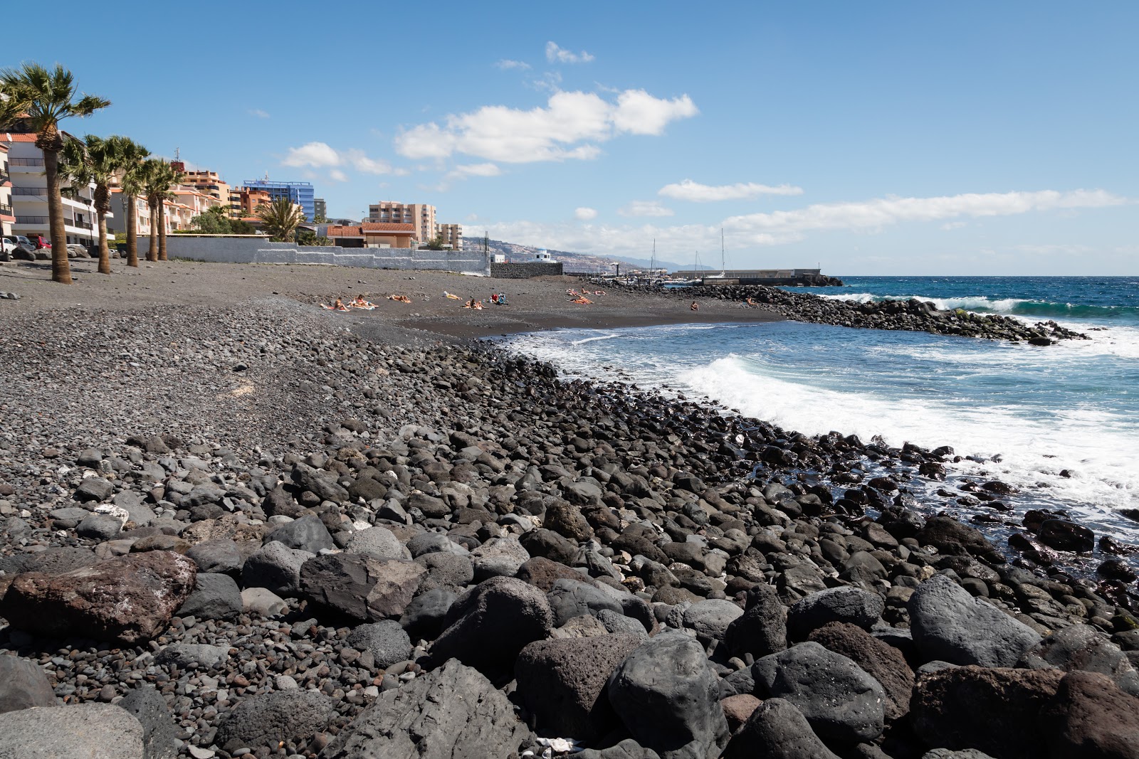 Valokuva Playa de Olegarioista. pinnalla harmaa hiekka ja kivet:n kanssa