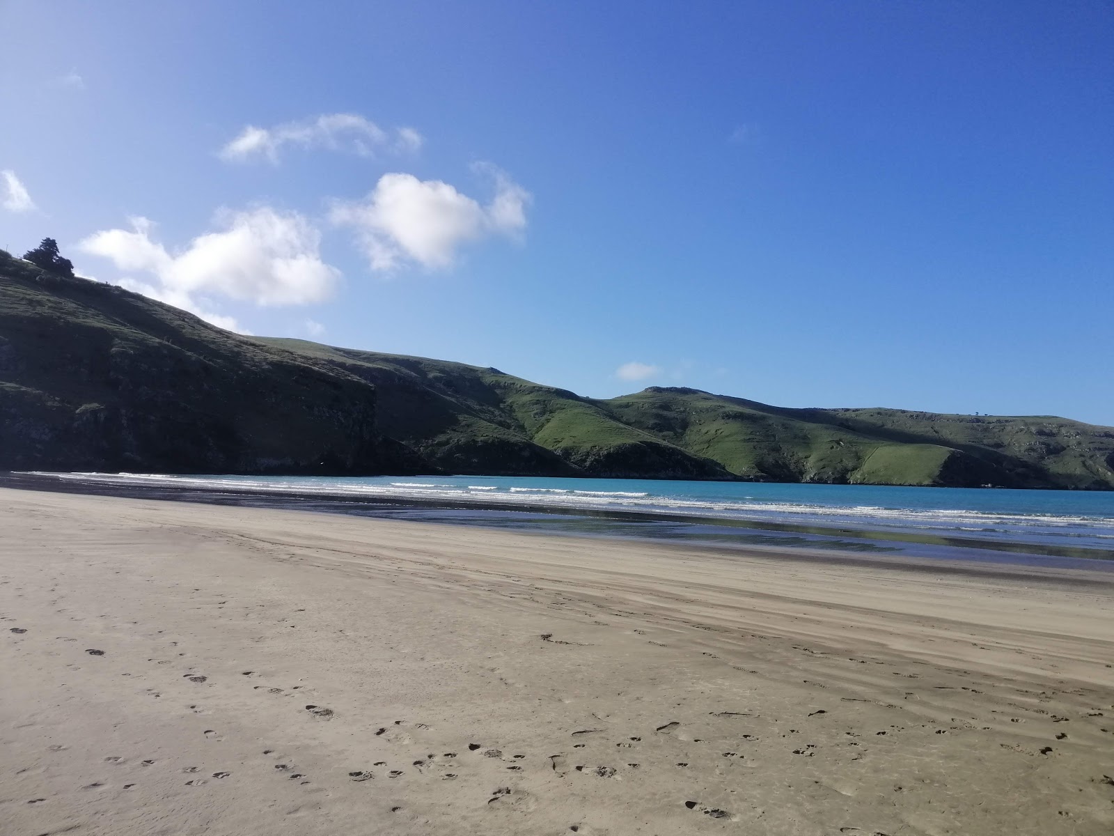 Foto de Le Bons Bay Beach con arena beige superficie