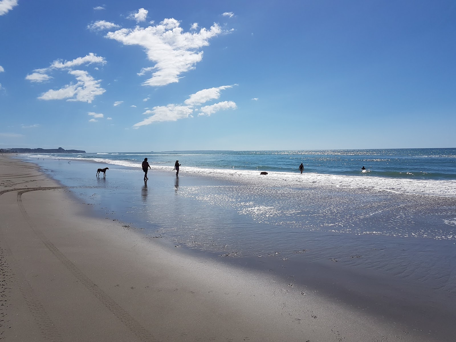 Fotografija Poutuia Beach z svetel pesek površino