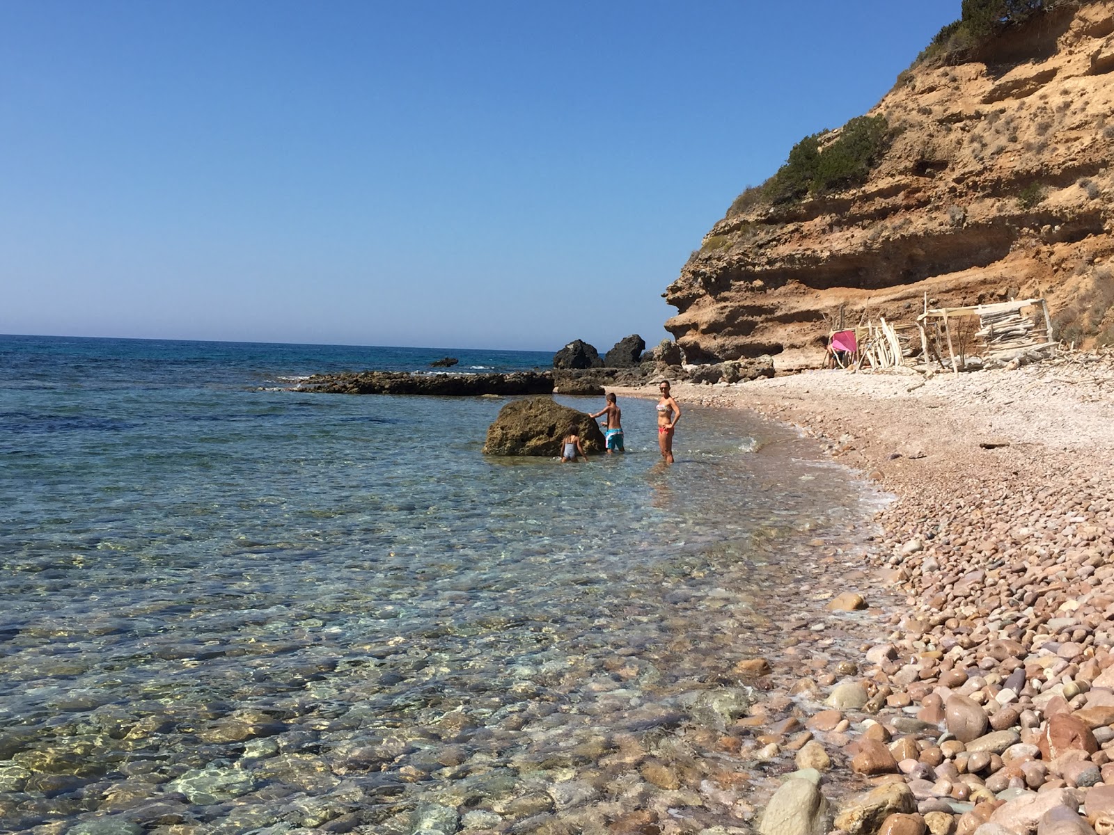 Foto di Cala Salto del Cervo con una superficie del ciottoli grigi