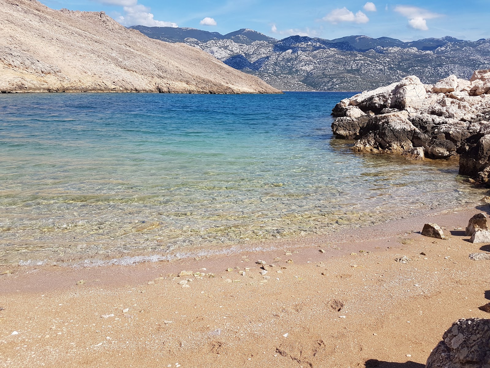 Foto di Baska slana beach sorretto da scogliere