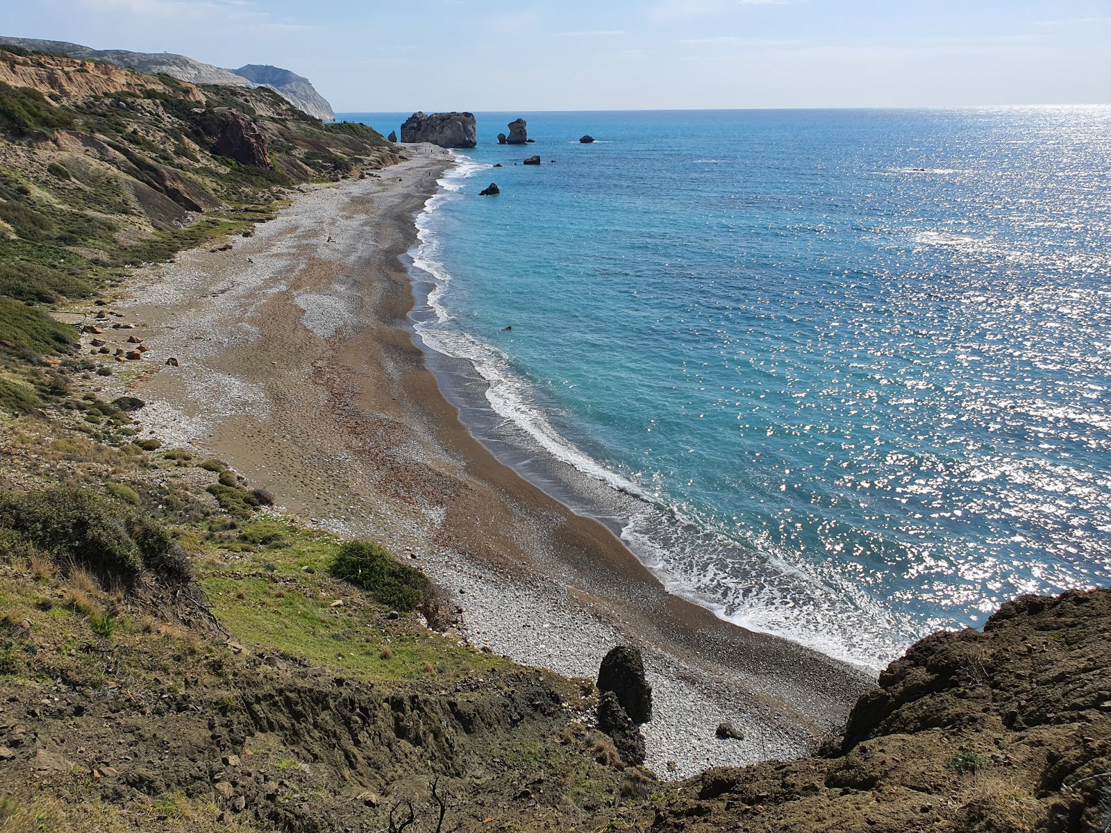 Foto di Aphrodite's rock beach con una superficie del ciottolo grigio