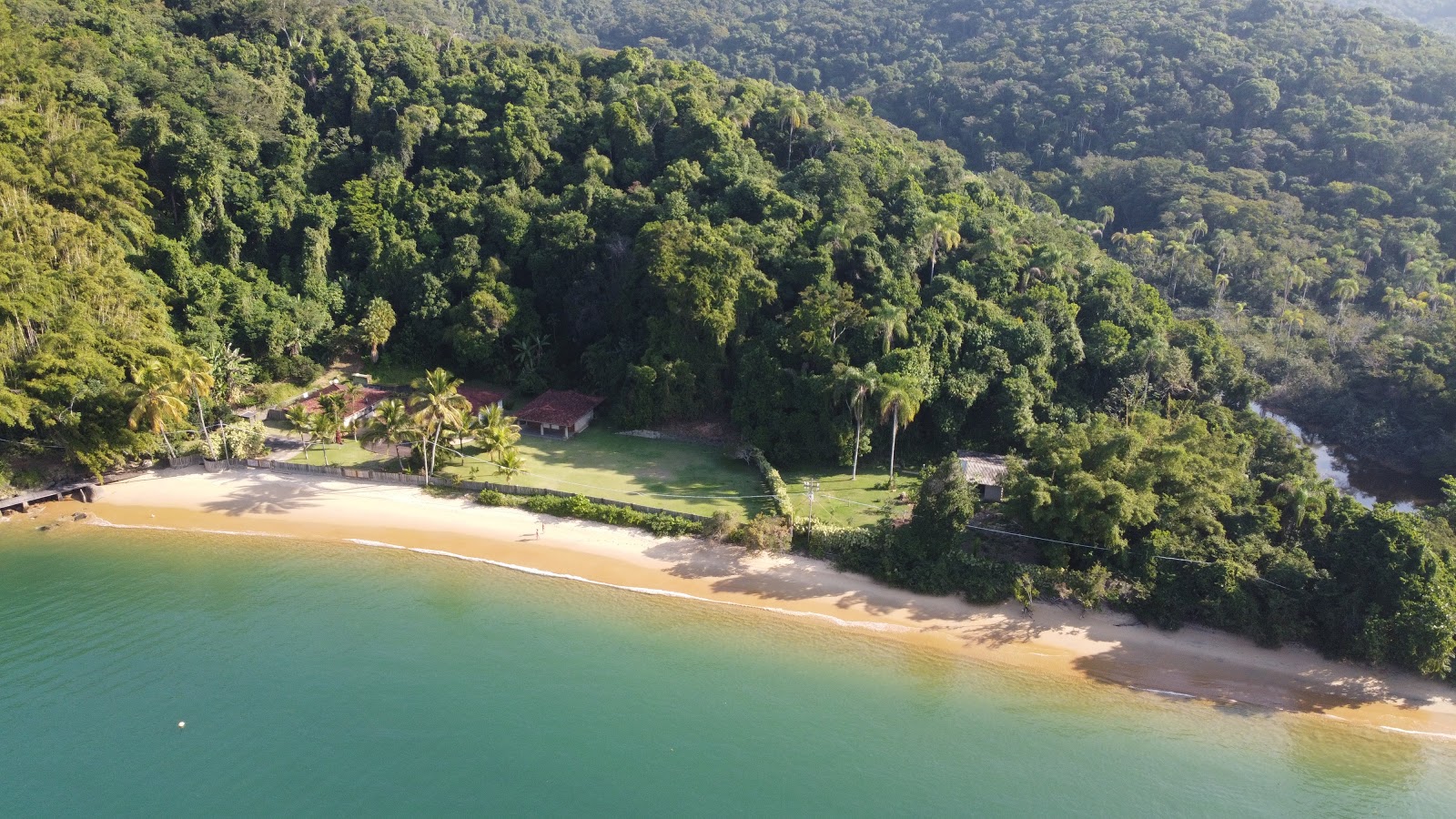 Foto di Praia do Pereque con una superficie del sabbia luminosa