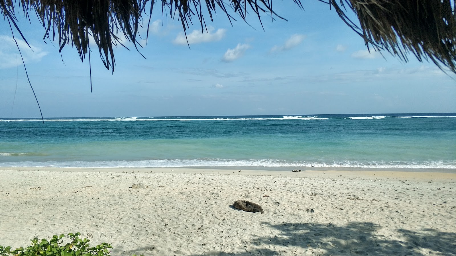 Foto von Torok Beach von Klippen umgeben