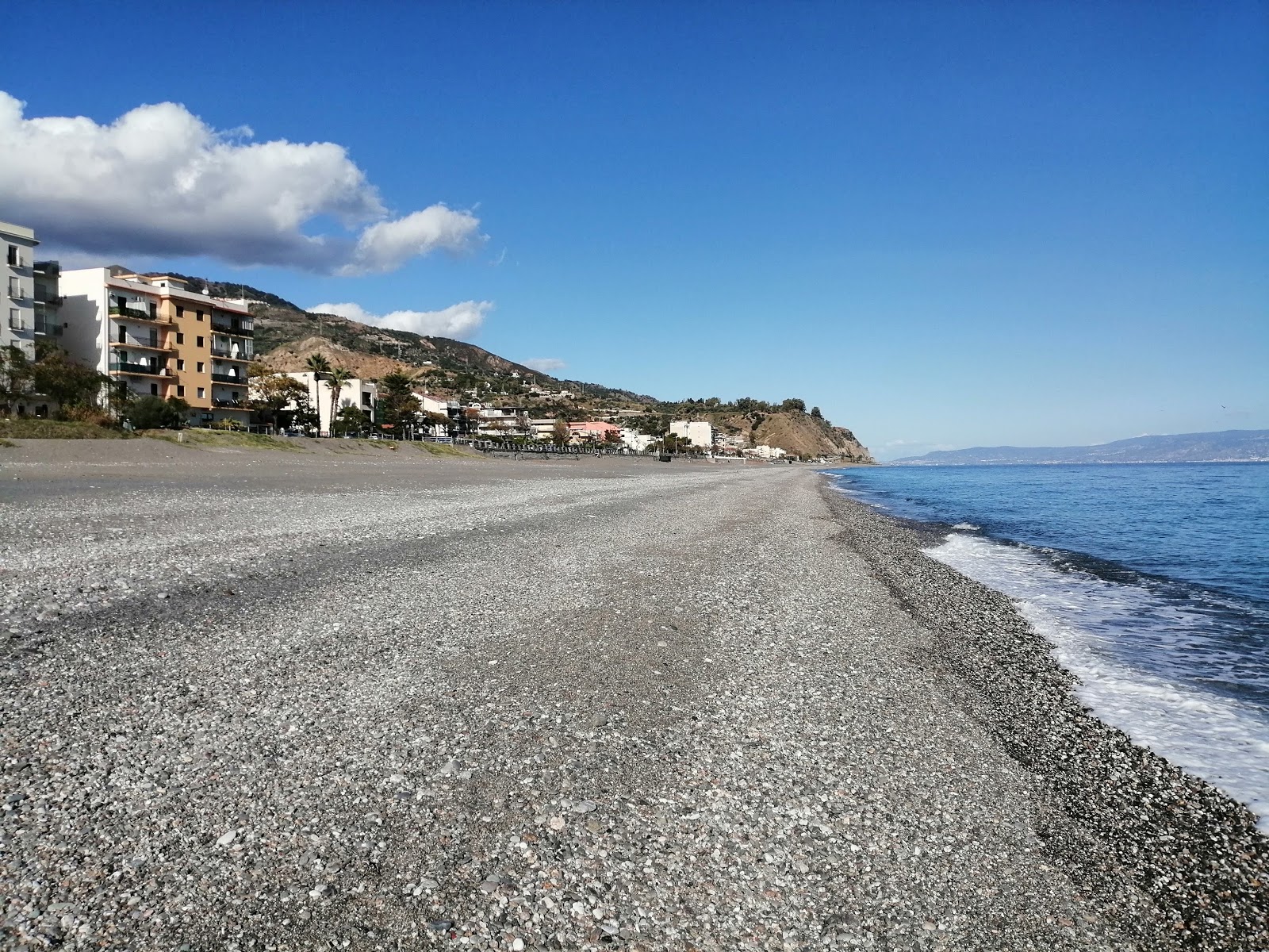 Foto de Spiaggia di Alì Terme com areia cinza e seixos superfície