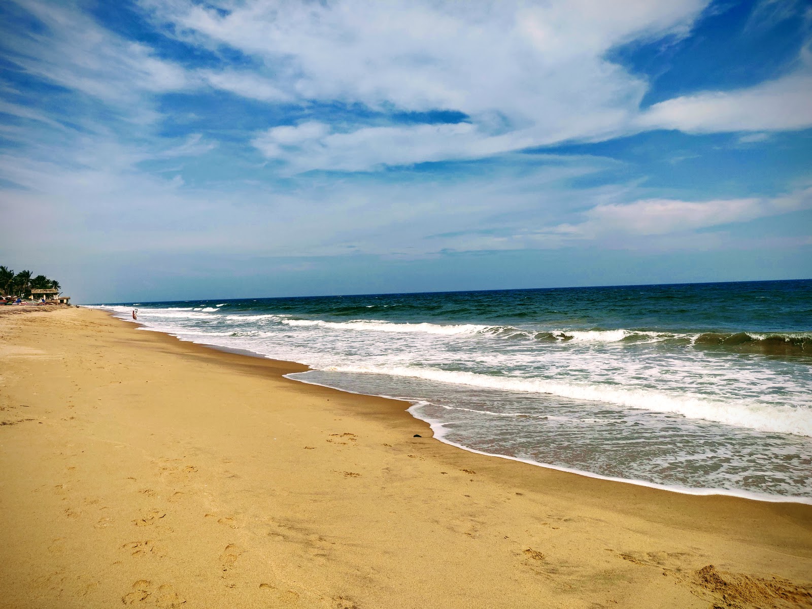 Valokuva Auroville Beachista. pinnalla kirkas hieno hiekka:n kanssa