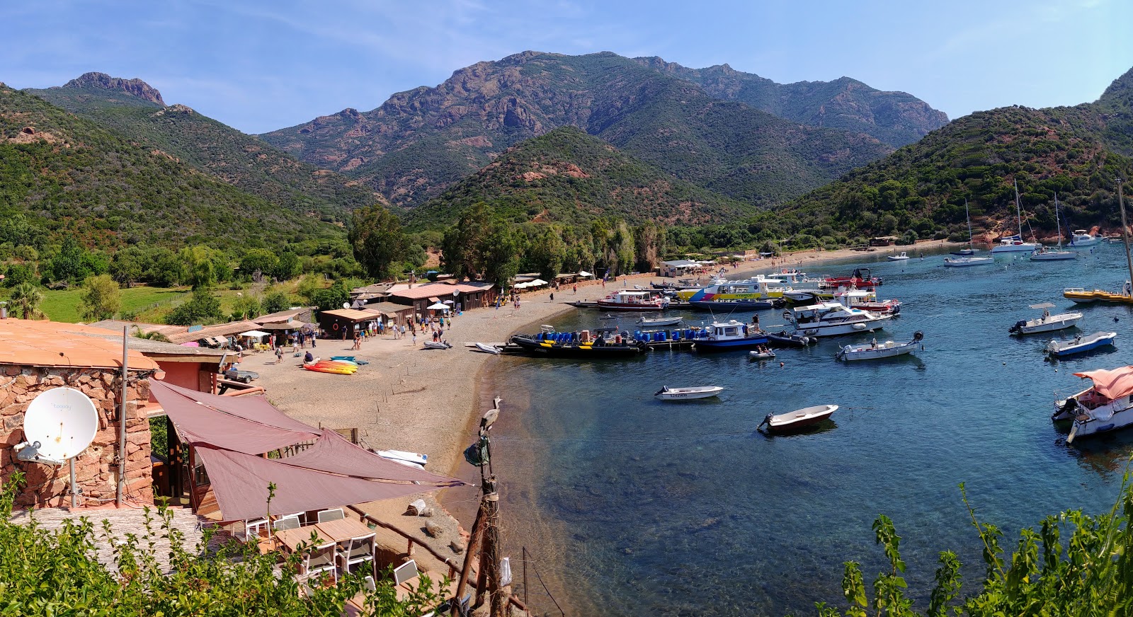 Foto di Girolata beach con una superficie del sabbia beige e ciottoli