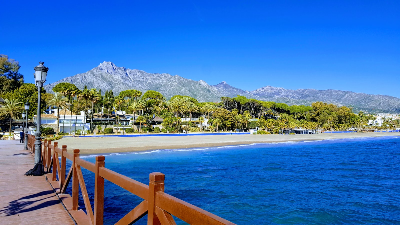 Fotografie cu Playa de Nagueles cu o suprafață de apă pură albastră