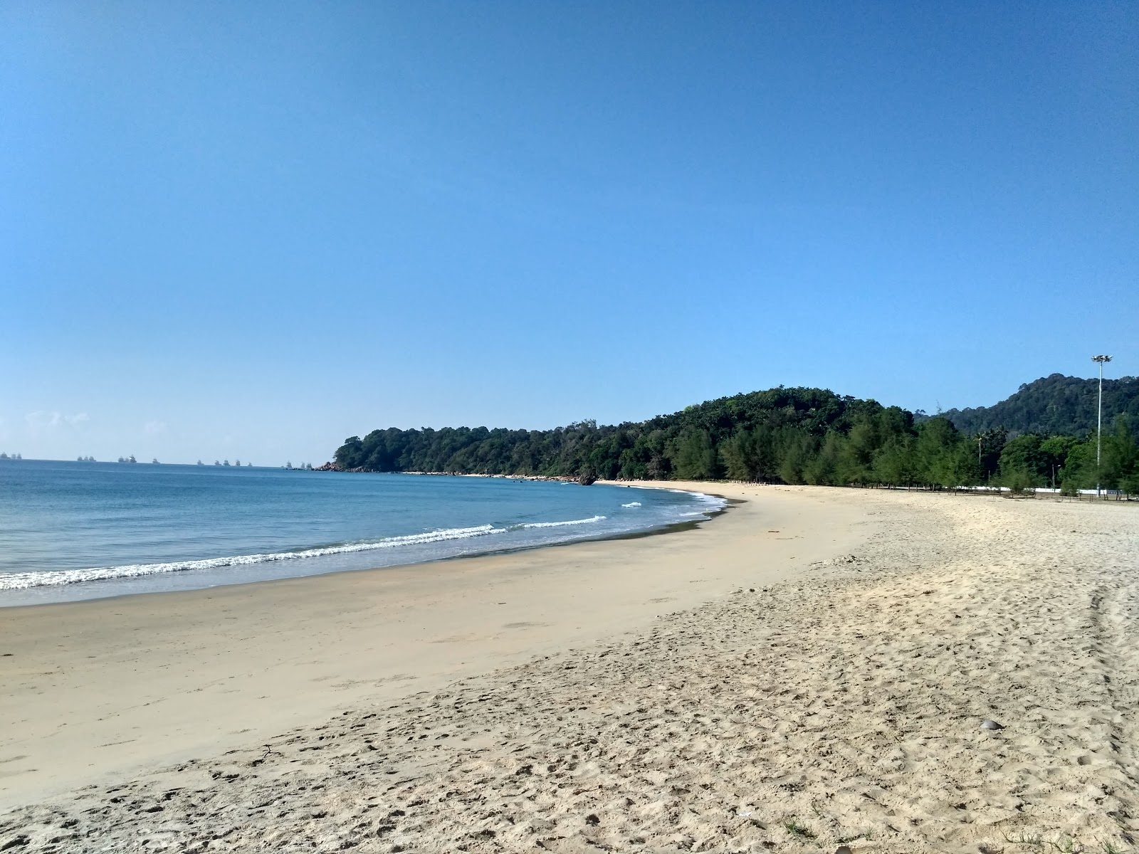 Foto av Teluk Kalong Beach med turkos rent vatten yta