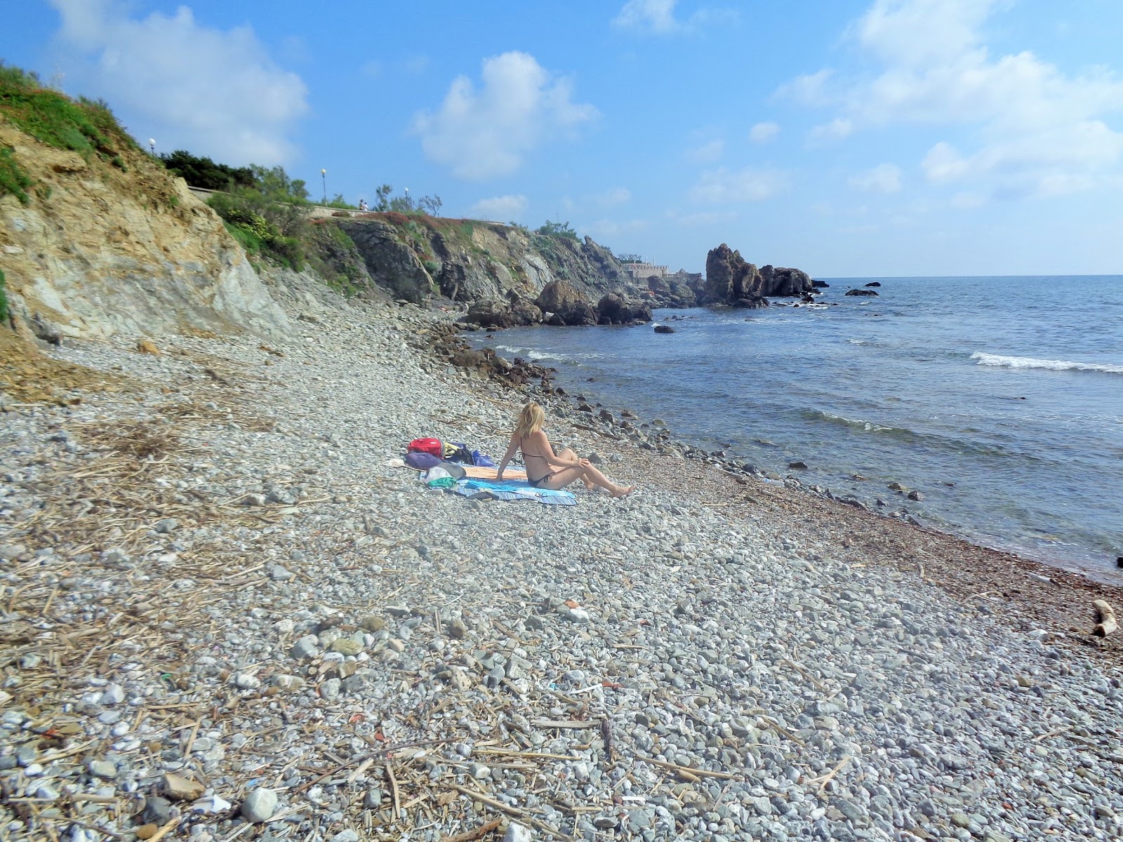 Valokuva Spiaggia Calalongaista. pinnalla harmaa hiekka ja kivet:n kanssa