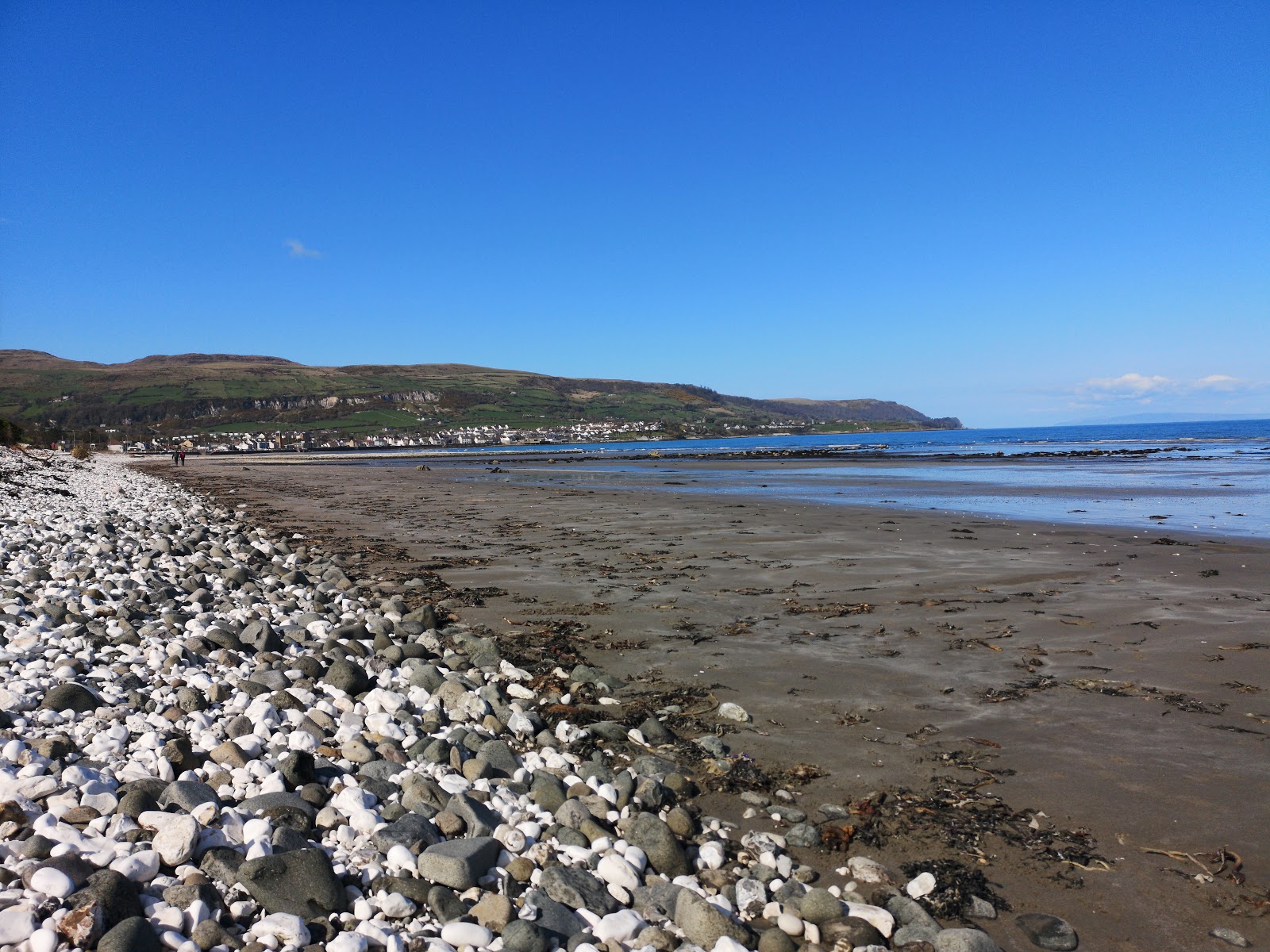 Photo of Carnlough Beach backed by cliffs