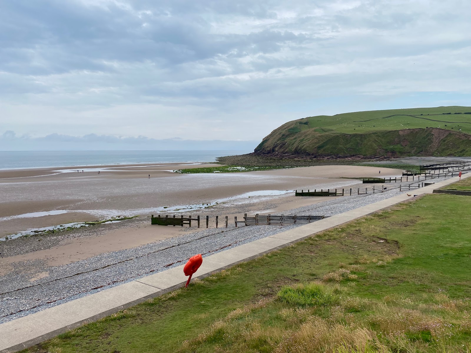 Foto av St bees beach omgiven av klippor