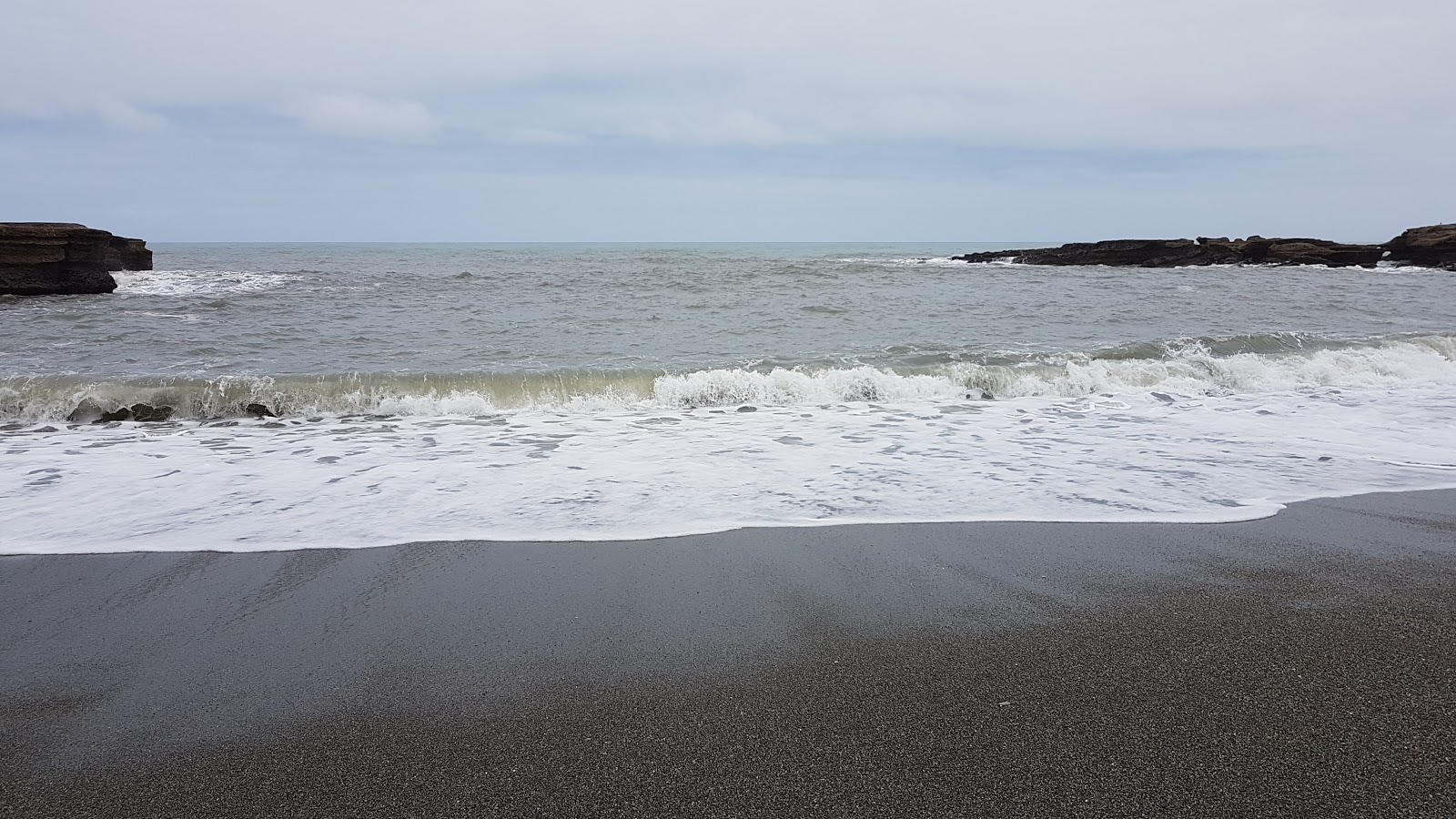 Foto van Punakaiki Beach ondersteund door kliffen