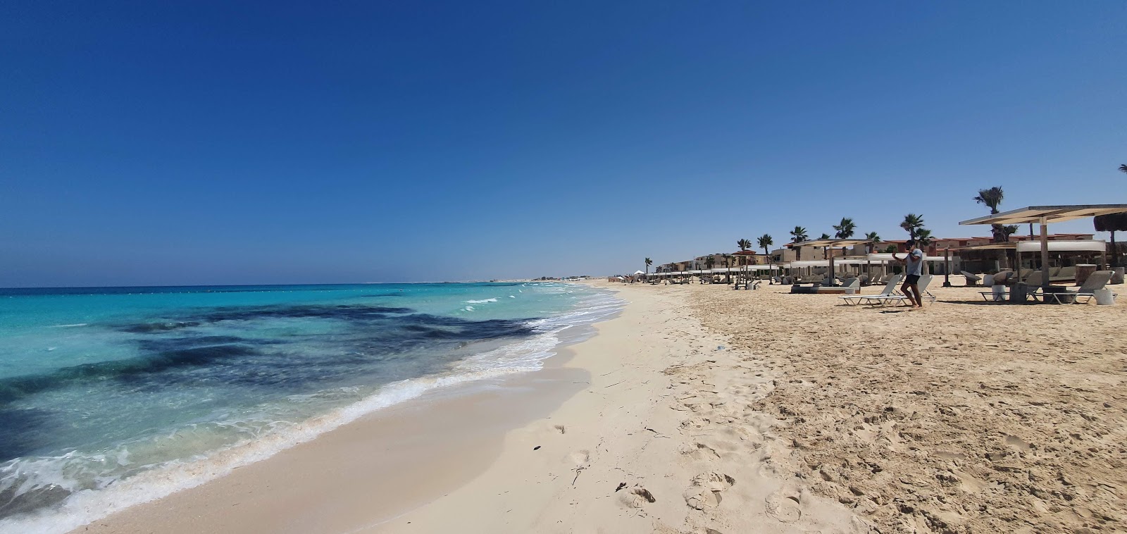 Foto de Marsa Baghush Beach com areia fina e brilhante superfície