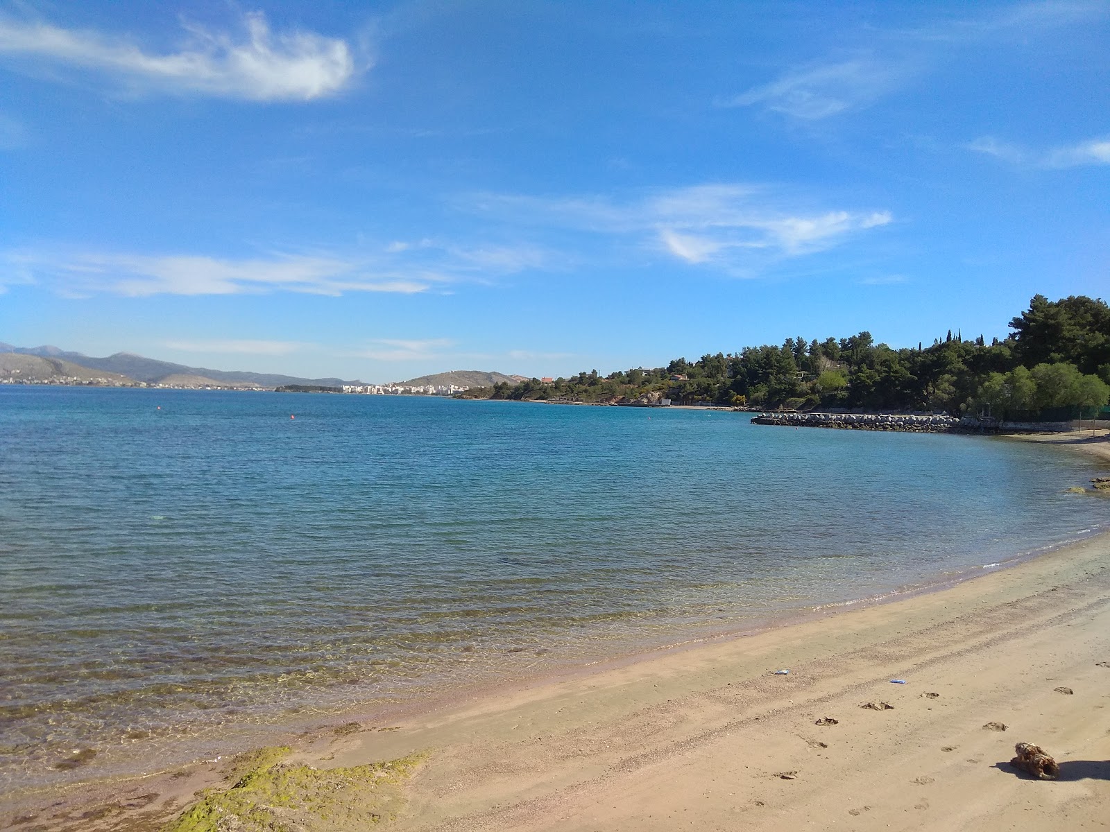 Foto av Amoudia beach med brunsand yta