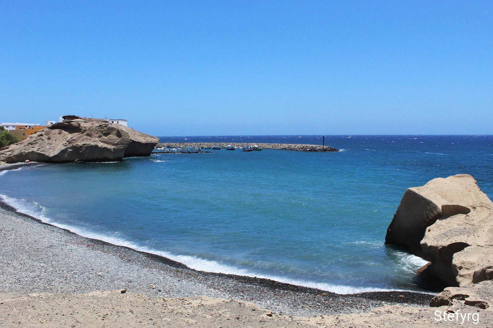Foto av Playa De Tajao med harmaa hiekka ja kivi yta
