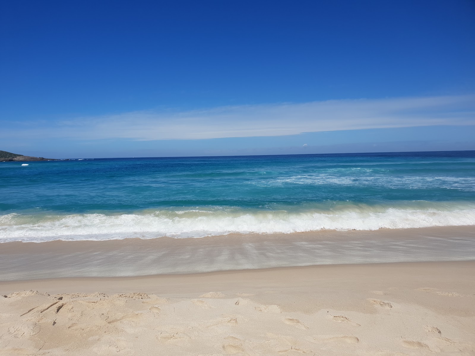 Foto von Conspicuous Cliff Beach umgeben von Bergen