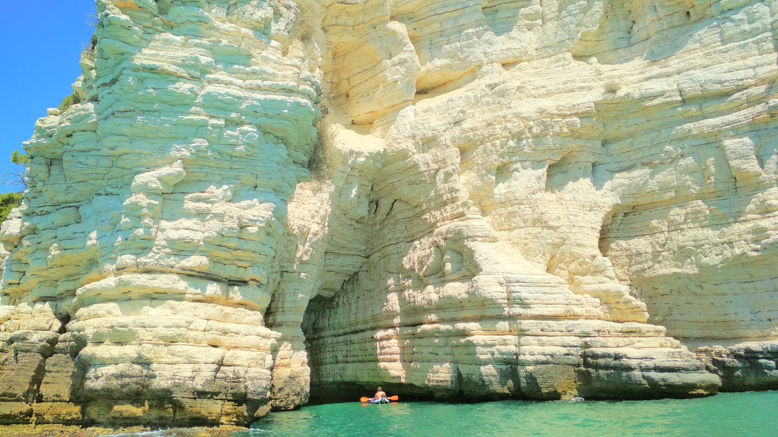 Valokuva Cala del Pescecaneista. pinnalla turkoosi puhdas vesi:n kanssa