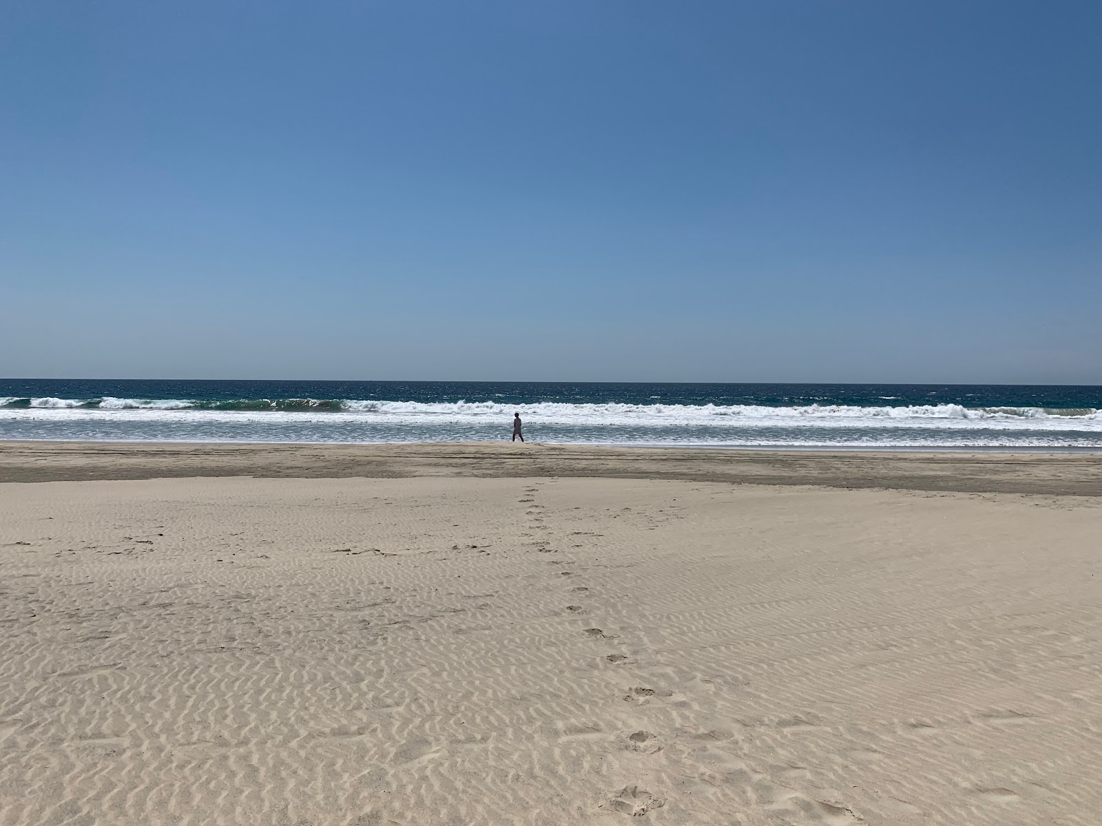 Foto di Playa El Tomatal con una superficie del sabbia beige fine