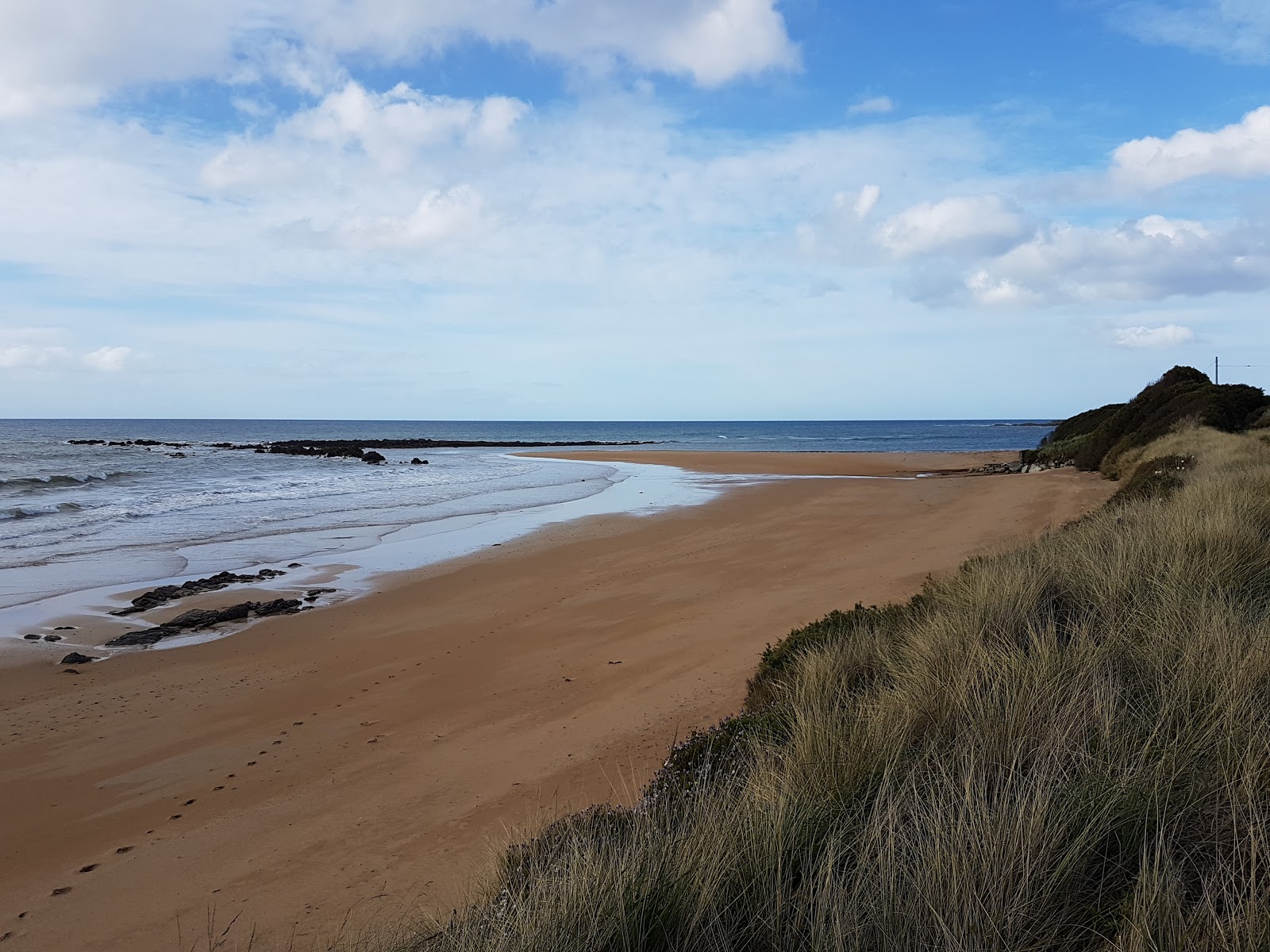 Foto van Cooee Beach met beige zand oppervlakte