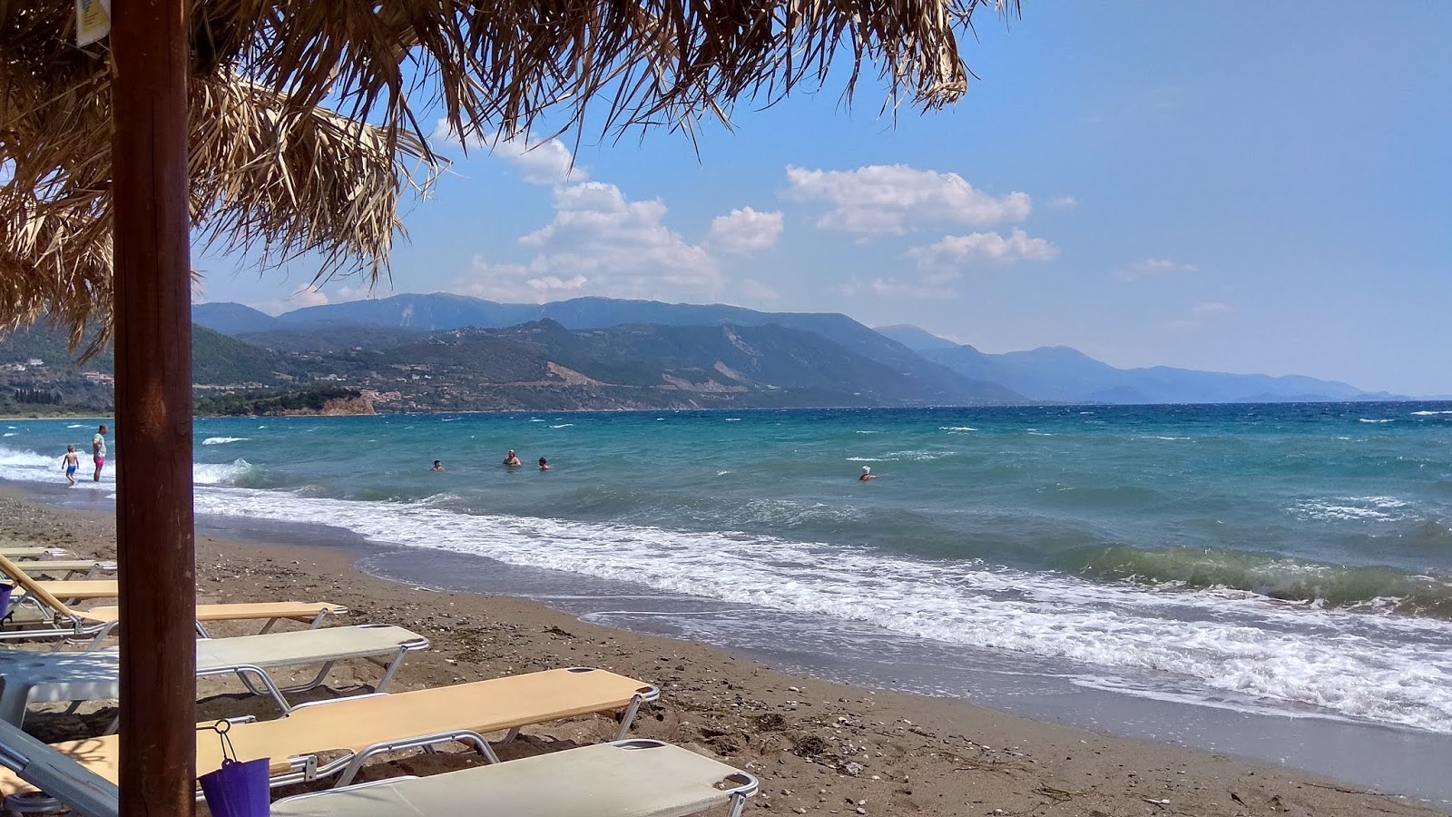 Foto di Chiliadou beach con una superficie del sabbia marrone