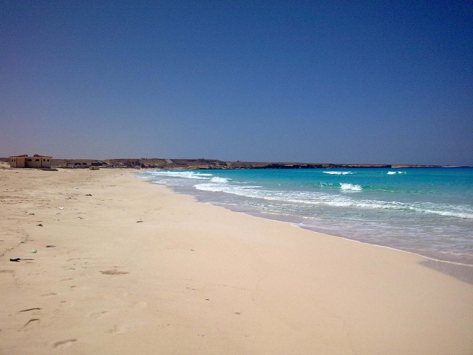 Foto van Umm al-Rakhm Beach met helder zand oppervlakte