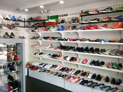 A shoe store with shelves displaying various sneakers in different colors and styles, with a glass display case on the left.