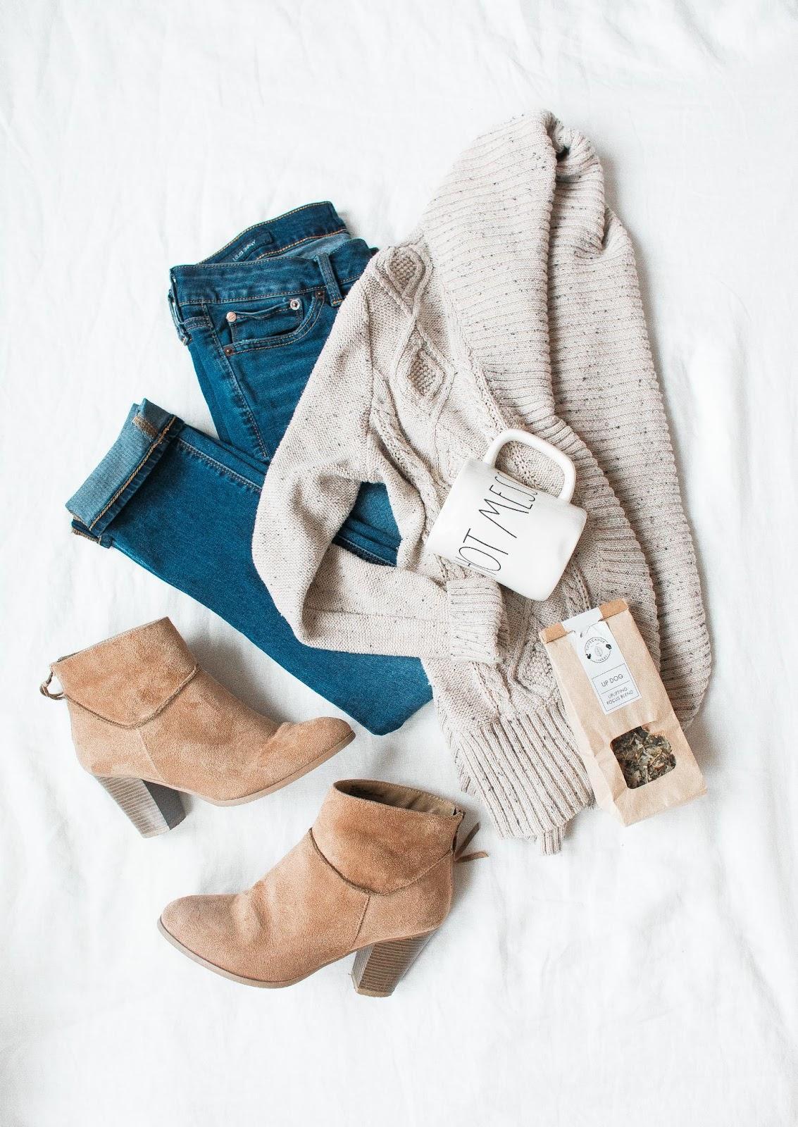 Styling tips: Timeless pieces such as blue denim jeans, coffee mug saying hot mess, bag of loose tea leaves, beige suede ankle booties, off-white long sleeve cardigan sweater