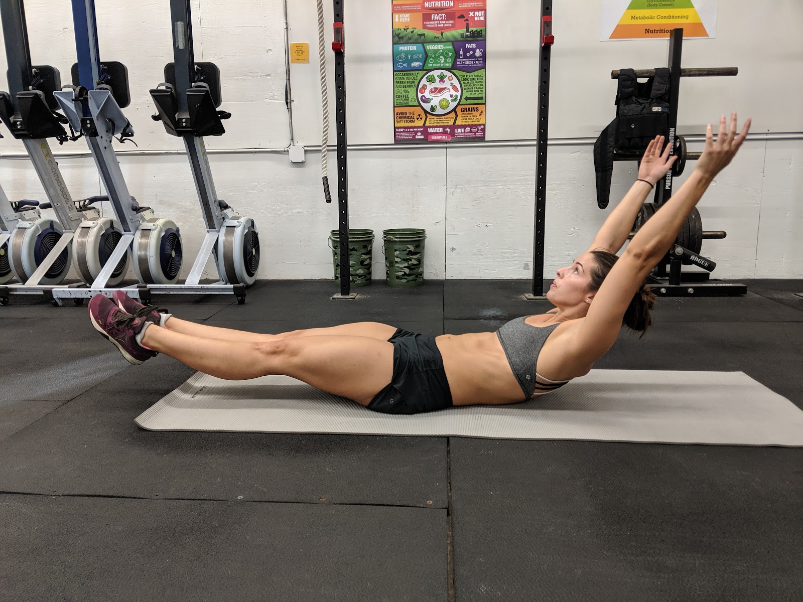 woman lying on floor of gym in hollow  hold position