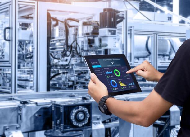 Smart industry control concept. Hands holding tablet on blurred automation machine as background automation of business processes stock pictures, royalty-free photos & images