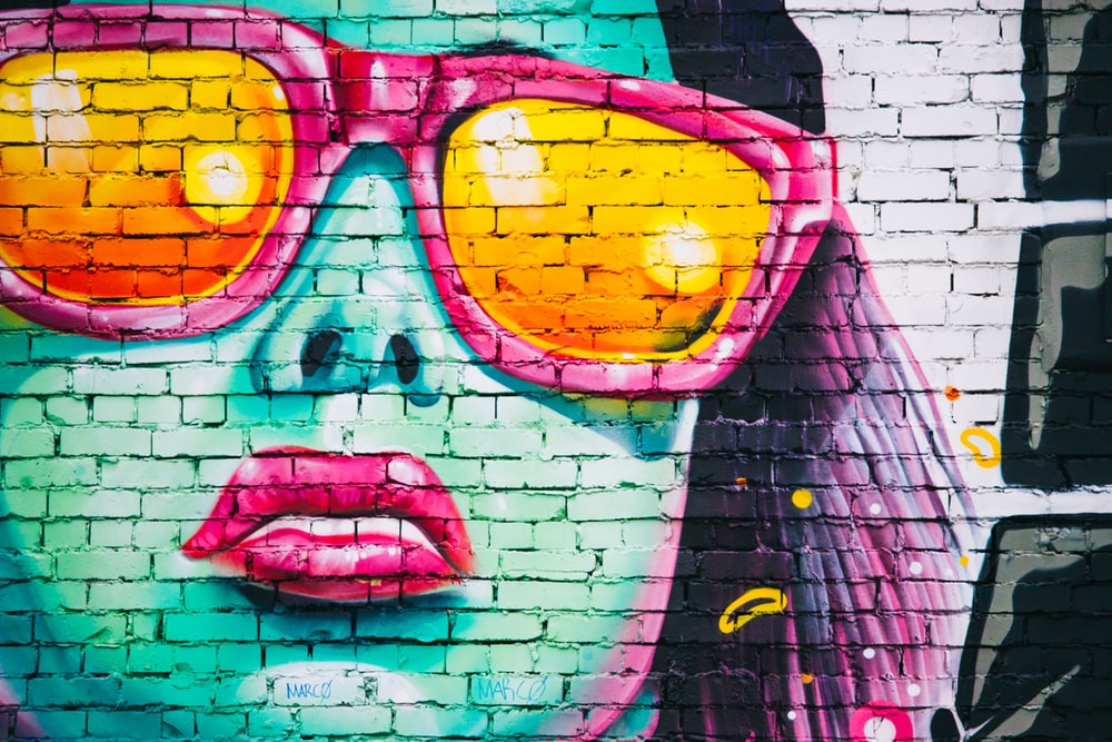 woman wearing sunglasses wall graffiti