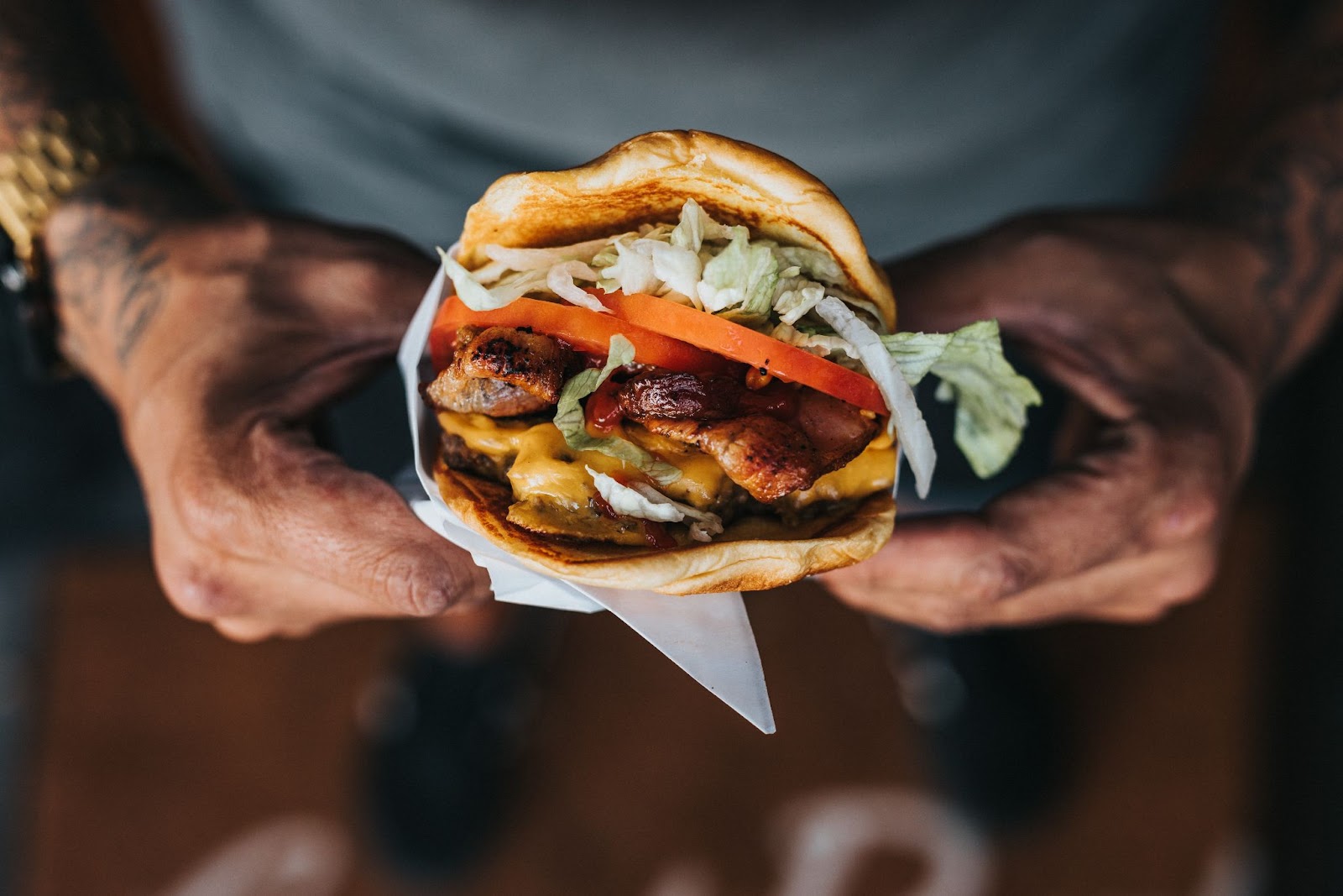 two hands holding a bacon cheeseburger in Kelowna