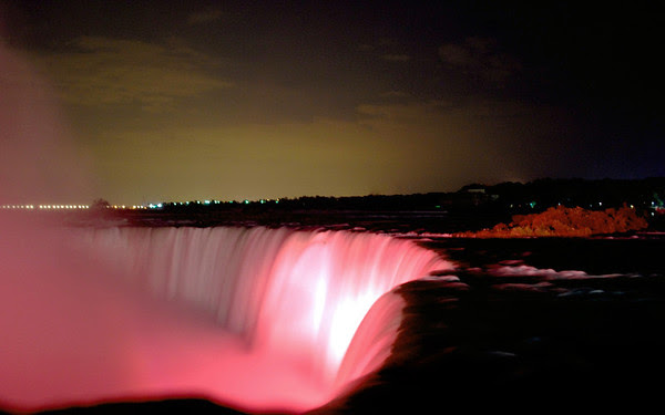 Water rushed over the Canadian Falls at night.