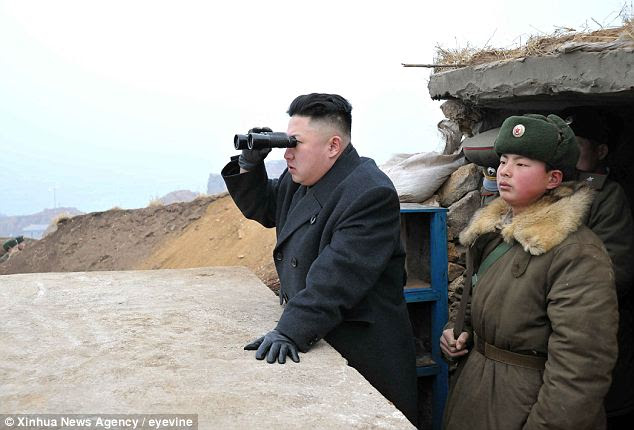 Better view: Kim Jong Un uses a pair of binoculars to look south during his inspection to of a front-line army unit