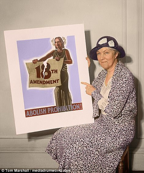 A woman shows off a poster reading, 'Abolish Prohibition!'