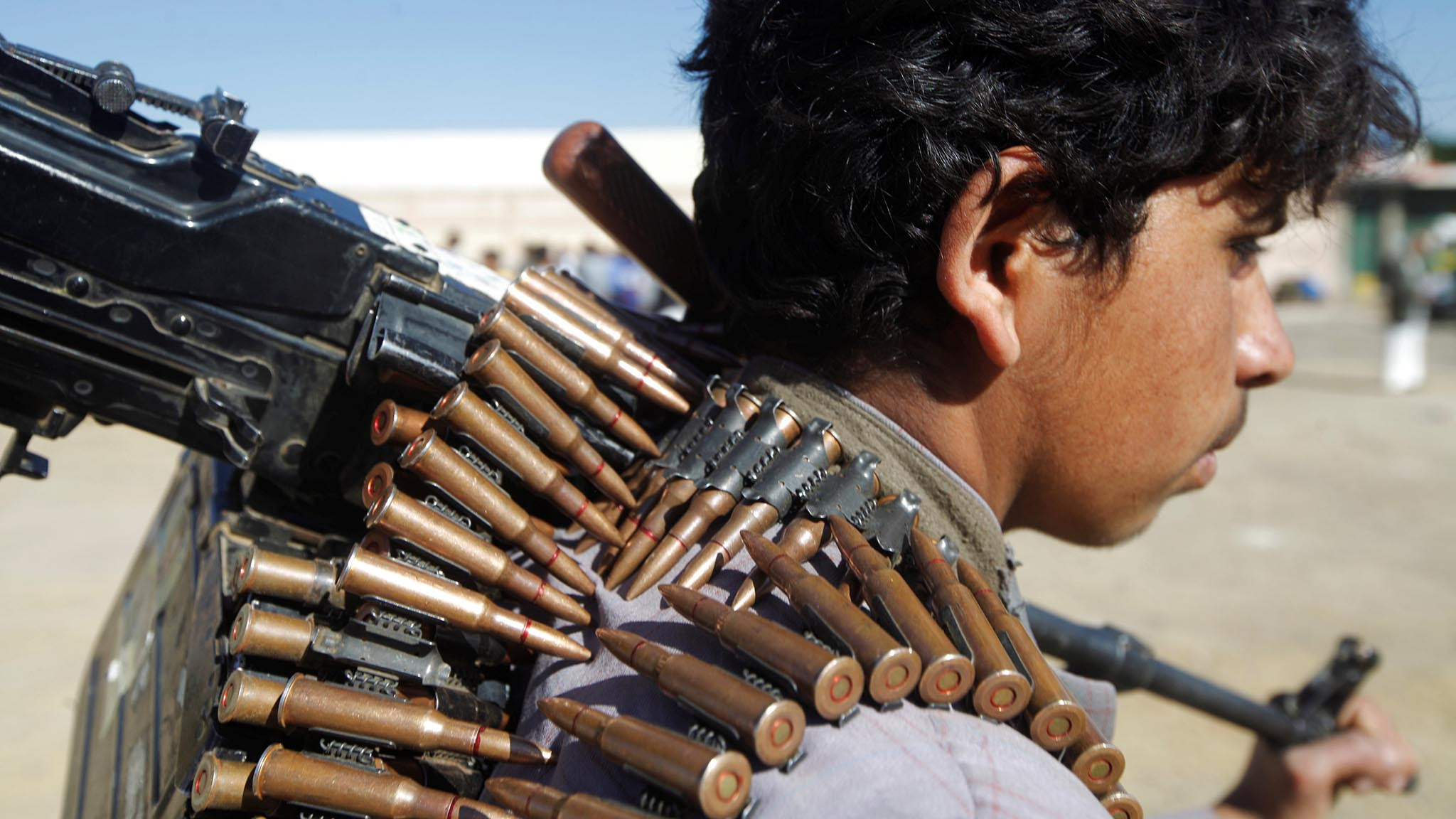 A Houthi rebel holds the barrel of a machine gun he carries during a rally held to mobilize fighters for battles against government forces, in Sanaa, Yemen