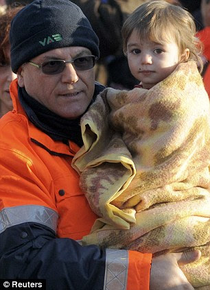 A rescue worker carries a child 