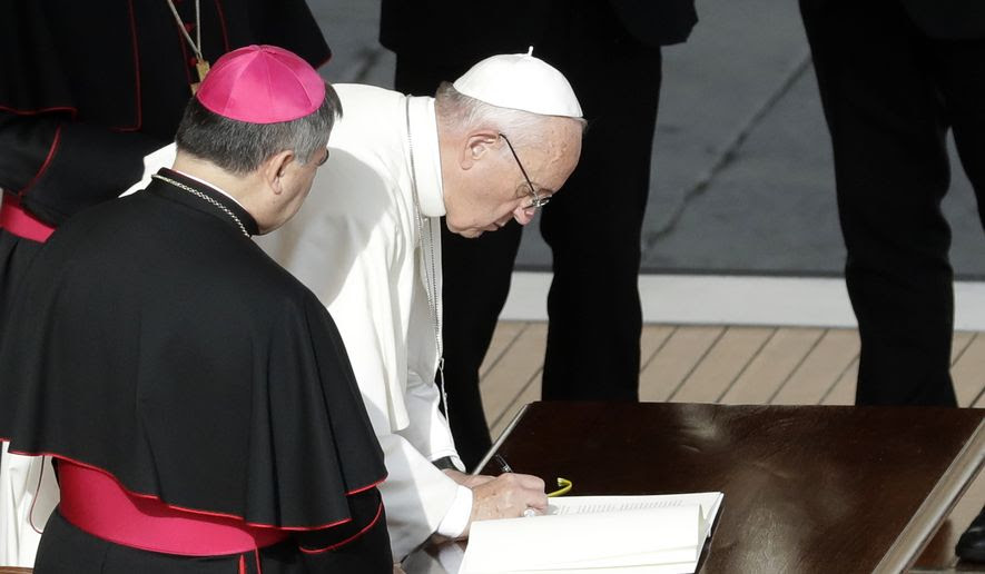 Pope Francis signs a letter at the end of a Mass on the occasion of the closing of the Holy Door of St. Peter's Basilica at the Vatican, Sunday, Nov. 20, 2016. The Vatican said the letter, addressed to all the church, expressed the pope's intention that the church can continue to live out the mercy with the same intensity felt during the entire special Jubilee Holy Year. (AP Photo/Gregorio Borgia)